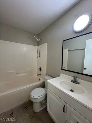 a bathroom with a toilet sink vanity tub and mirror