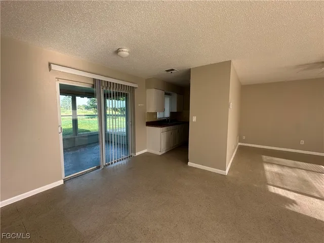 a view of an empty room with a kitchen