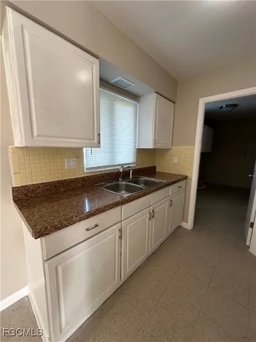 a kitchen with granite countertop a sink and a stove top oven