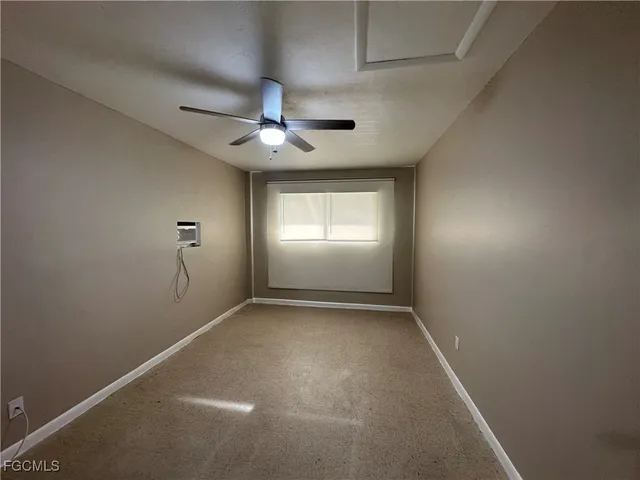 en empty room with windows and ceiling fan