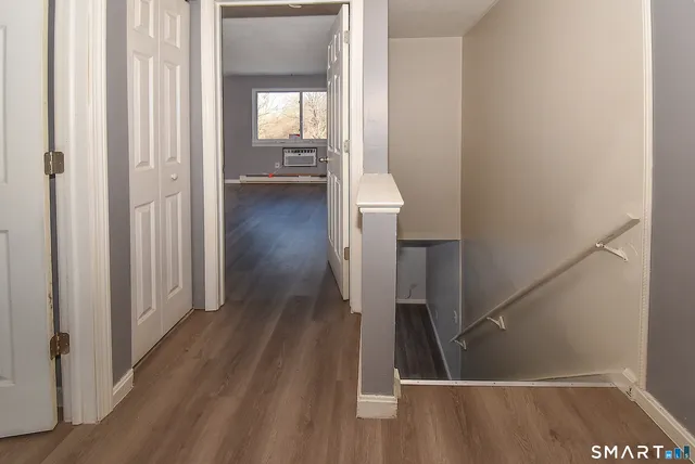 a view of a hallway with wooden floor and staircase
