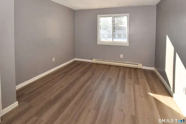 wooden floor in an empty room with a window