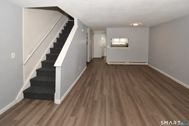 a view of entryway and hall with wooden floor