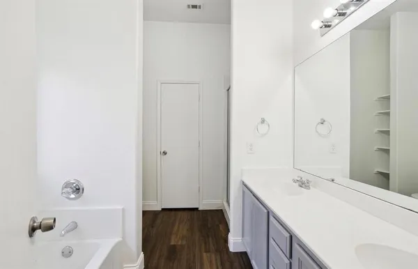 a bathroom with a tub sink and mirror