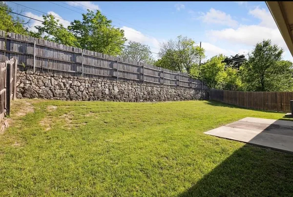 a view of a yard with wooden fence