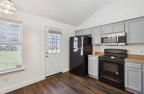a kitchen with granite countertop a refrigerator stove and microwave