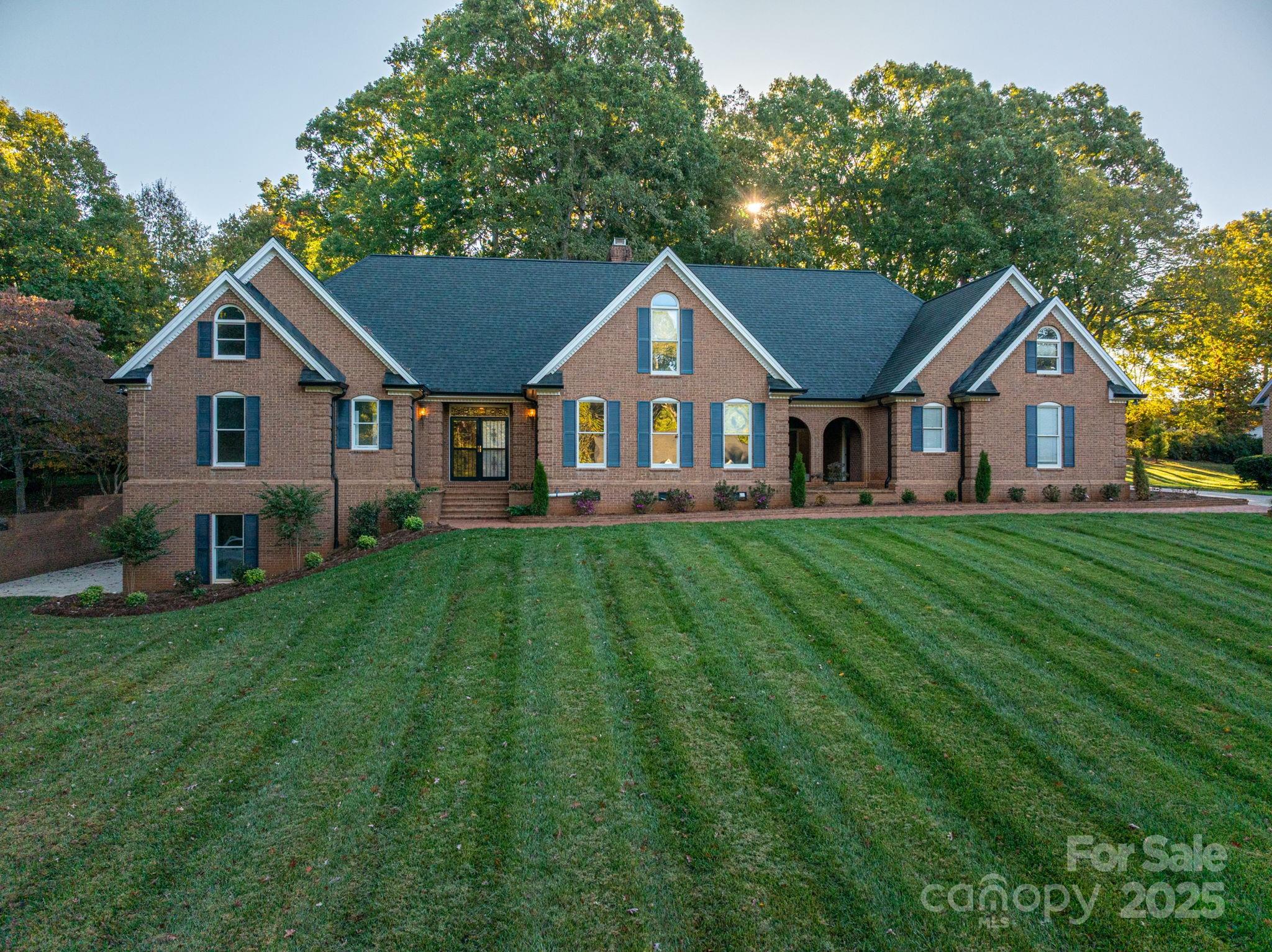 a front view of a house with a yard and trees