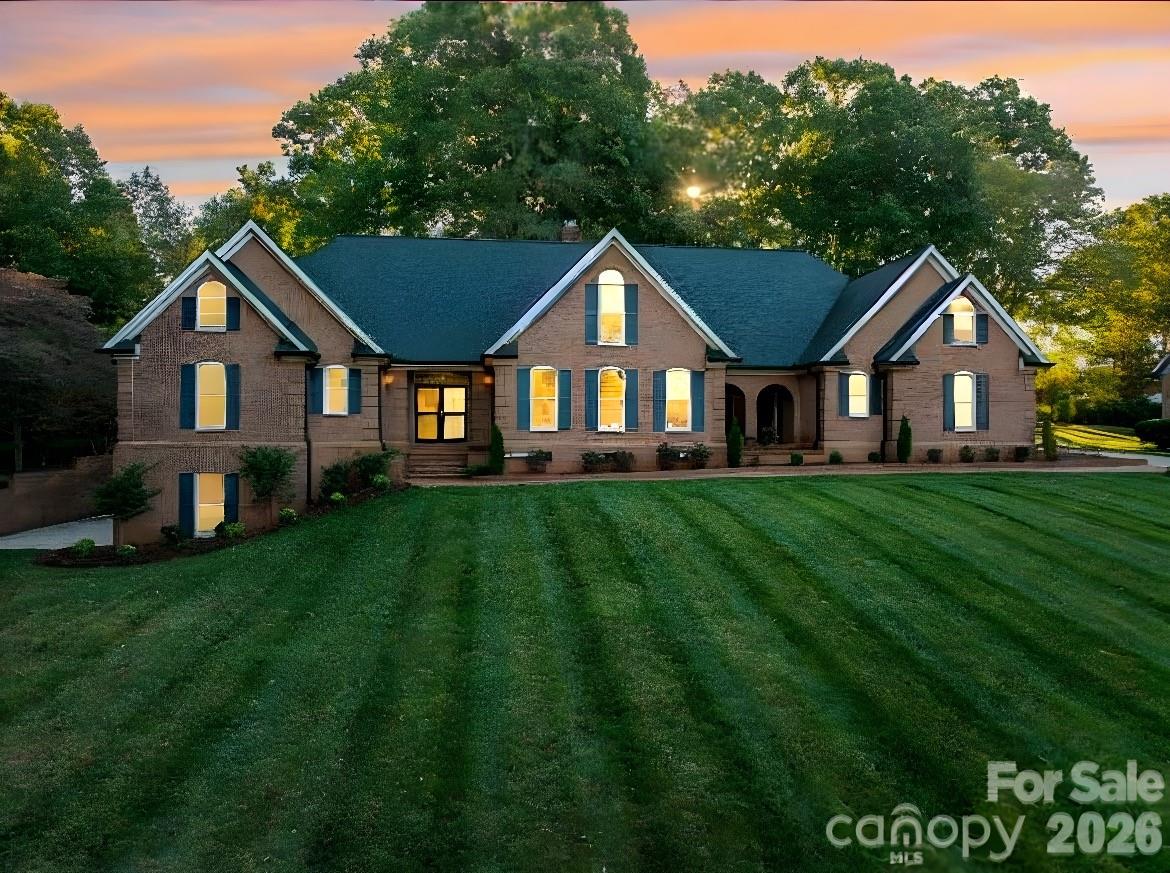 a front view of a house with a garden and trees