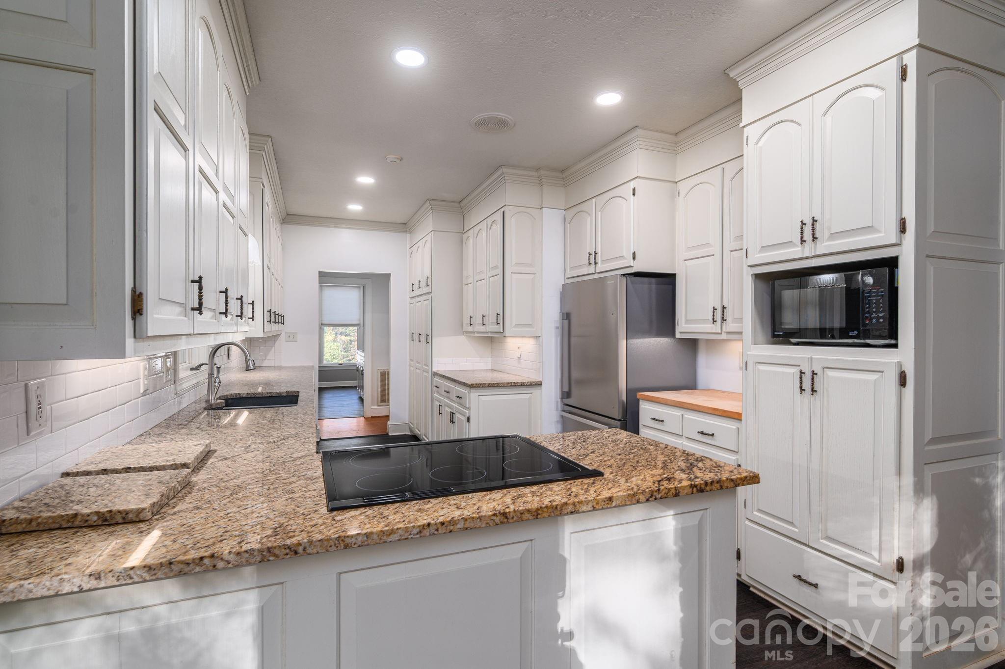 208 Hollow Road Lincolnton, NC 28092 - Photo 11 of 48 a kitchen with stainless steel appliances granite countertop a sink stove and microwave