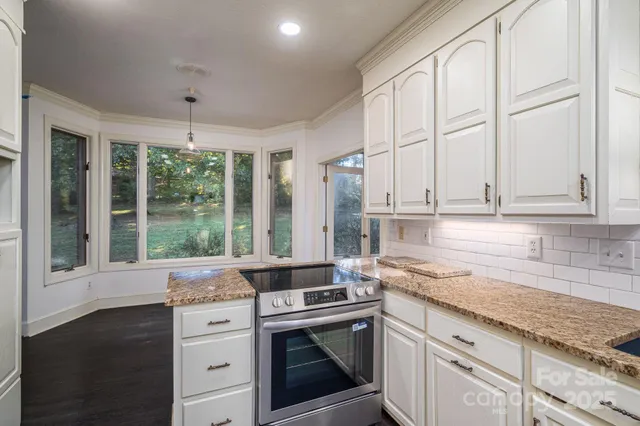 a kitchen with stainless steel appliances white cabinets and a granite counter tops