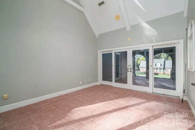 a view of an empty room with floor to ceiling window and front door