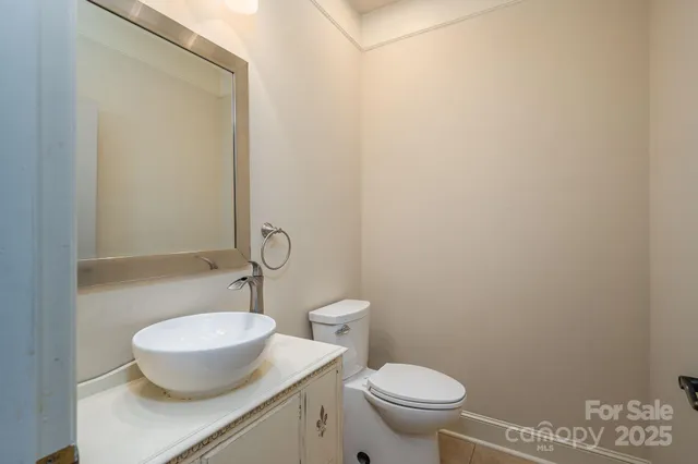 a bathroom with a granite countertop toilet and a sink