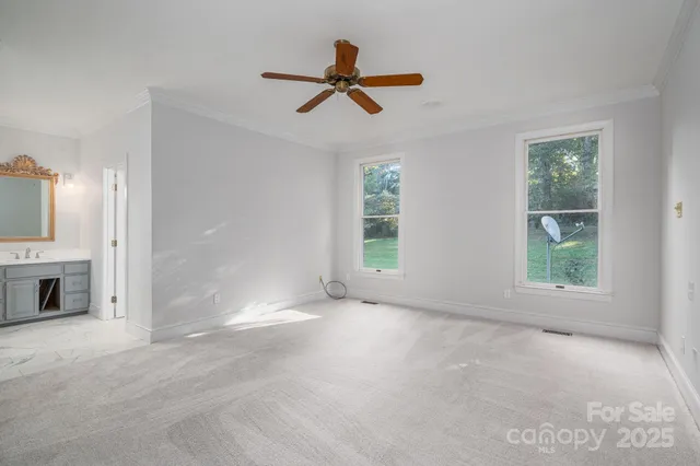a view of empty room with windows and ceiling fan