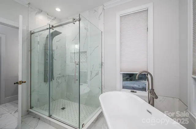 a bathroom with a shower bathtub mirror and toilet