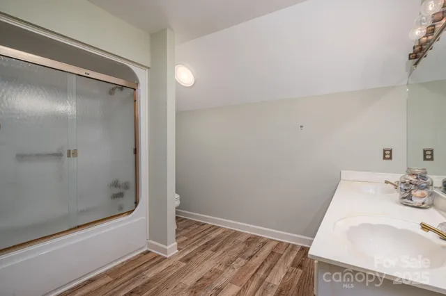 a bathroom with a tub shower vanity and a sink