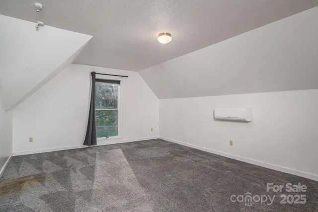 an empty room with an entryway and window