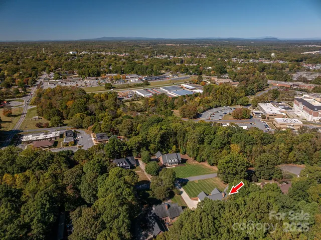 an aerial view of residential houses with outdoor space and trees