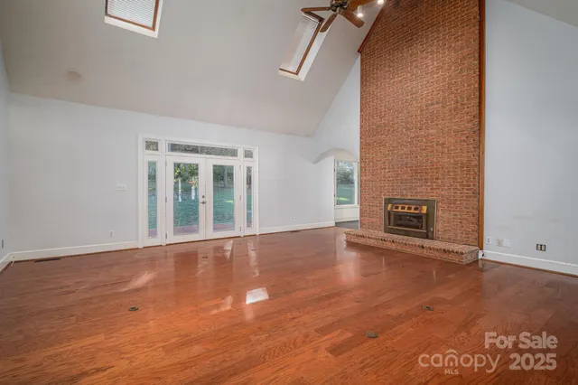 an empty room with wooden floor and fireplace