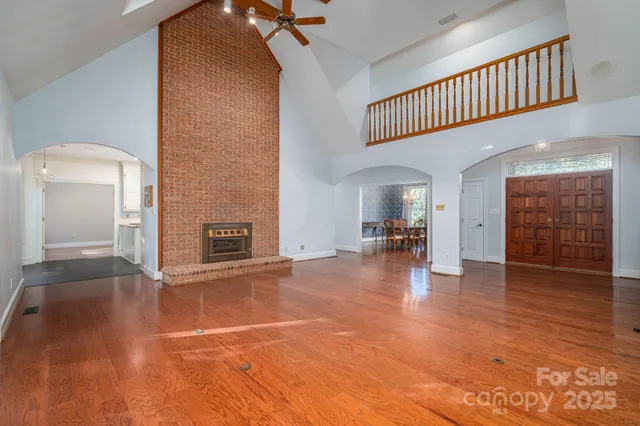 a view of a hallway with wooden floor and a room