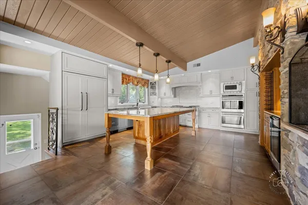 a kitchen with stainless steel appliances a refrigerator and a stove top oven