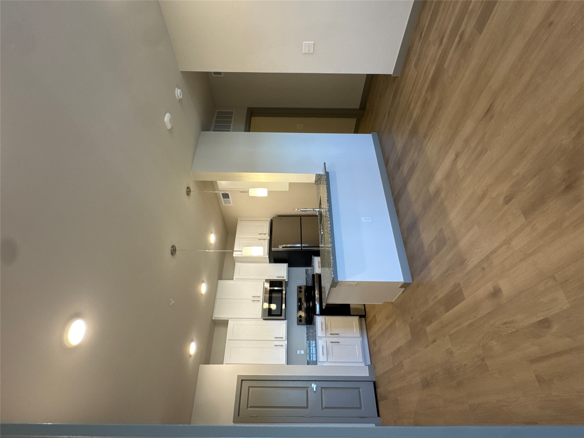 691 Union Chapel Road, Unit B1 Cedar Creek, TX 78612 - Photo 6 of 28 Kitchen featuring white cabinetry, appliances with stainless steel finishes, pendant lighting, a peninsula, and dark stone counters