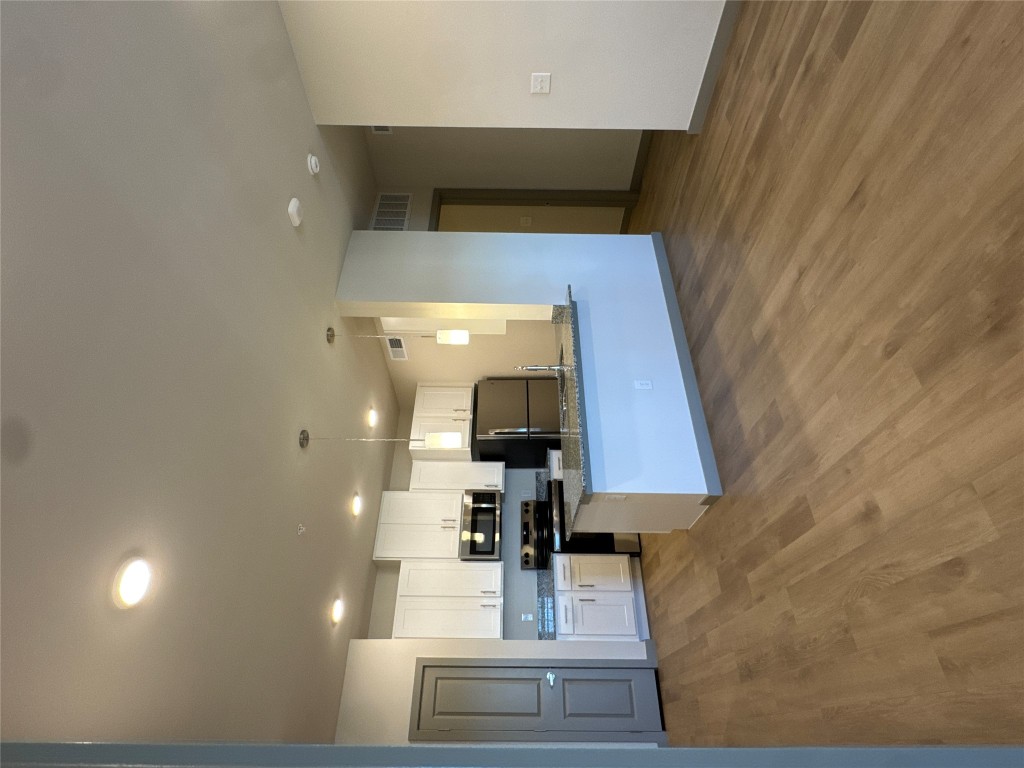 691 Union Chapel Road, Unit B1 Cedar Creek, TX 78612 - Photo 6 of 28 Kitchen featuring white cabinetry, appliances with stainless steel finishes, pendant lighting, a peninsula, and dark stone counters