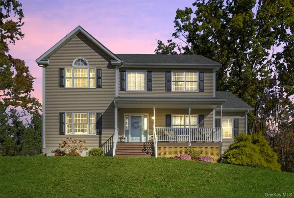 a front view of a house with a garden and yard