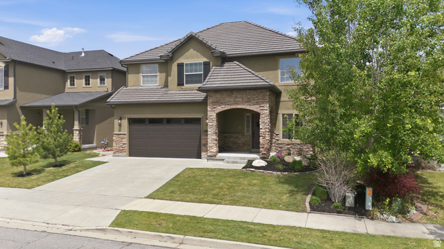 2007 Fielding Hill Lane Draper, UT 84020 - Photo 4 of 83 Two-story residence featuring a stucco exterior with stone accents, a tile roof, an attached two-car garage, mature landscaping, and a concrete driveway