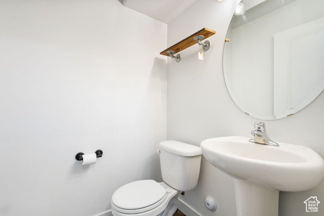 3456 South Linden Way Syracuse, UT 84075 - Photo 16 of 50 Half bathroom featuring baseboards, toilet, and a sink