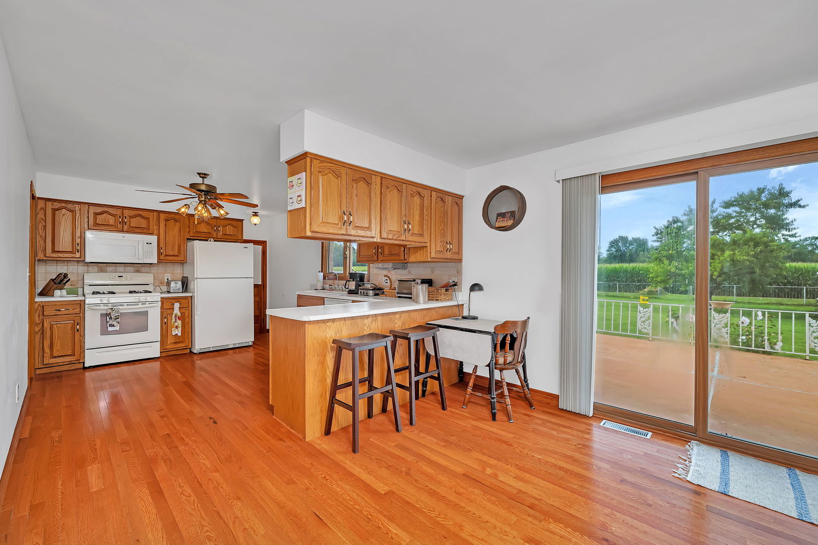 1413 Sharon Road Streator, IL 61364 - Photo 8 of 32 a view of a kitchen with dining space wooden floor electric appliances and windows
