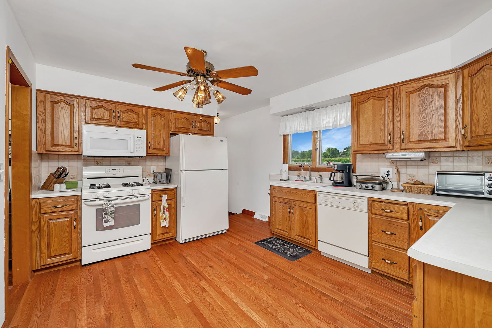 1413 Sharon Road Streator, IL 61364 - Photo 9 of 32 a kitchen with stainless steel appliances granite countertop a refrigerator a stove top oven a sink dishwasher and white cabinets with wooden floor