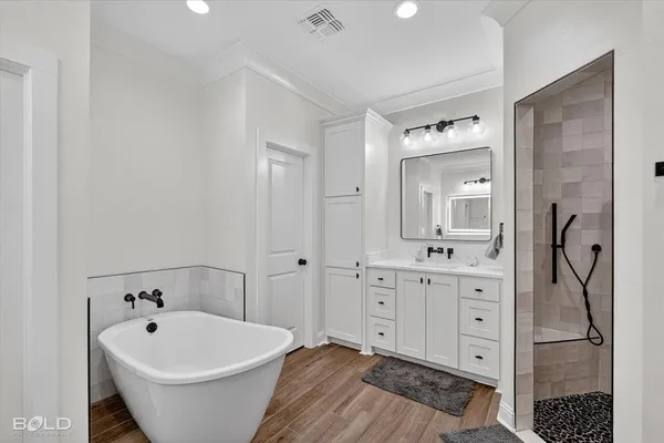 a spacious bathroom with a bathtub sink and mirror
