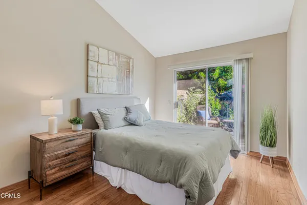 a bedroom with a bed table and a large window