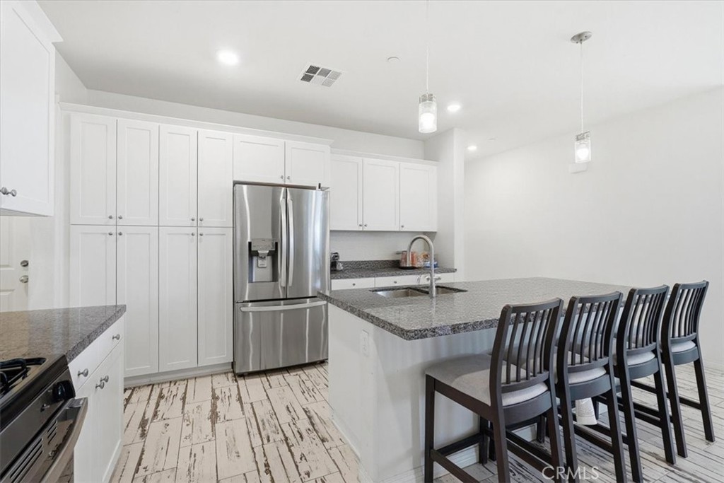 32350 Iron Trail Road Winchester, CA 92596 - Photo 10 of 32 a kitchen with kitchen island a wooden floor and stainless steel appliances