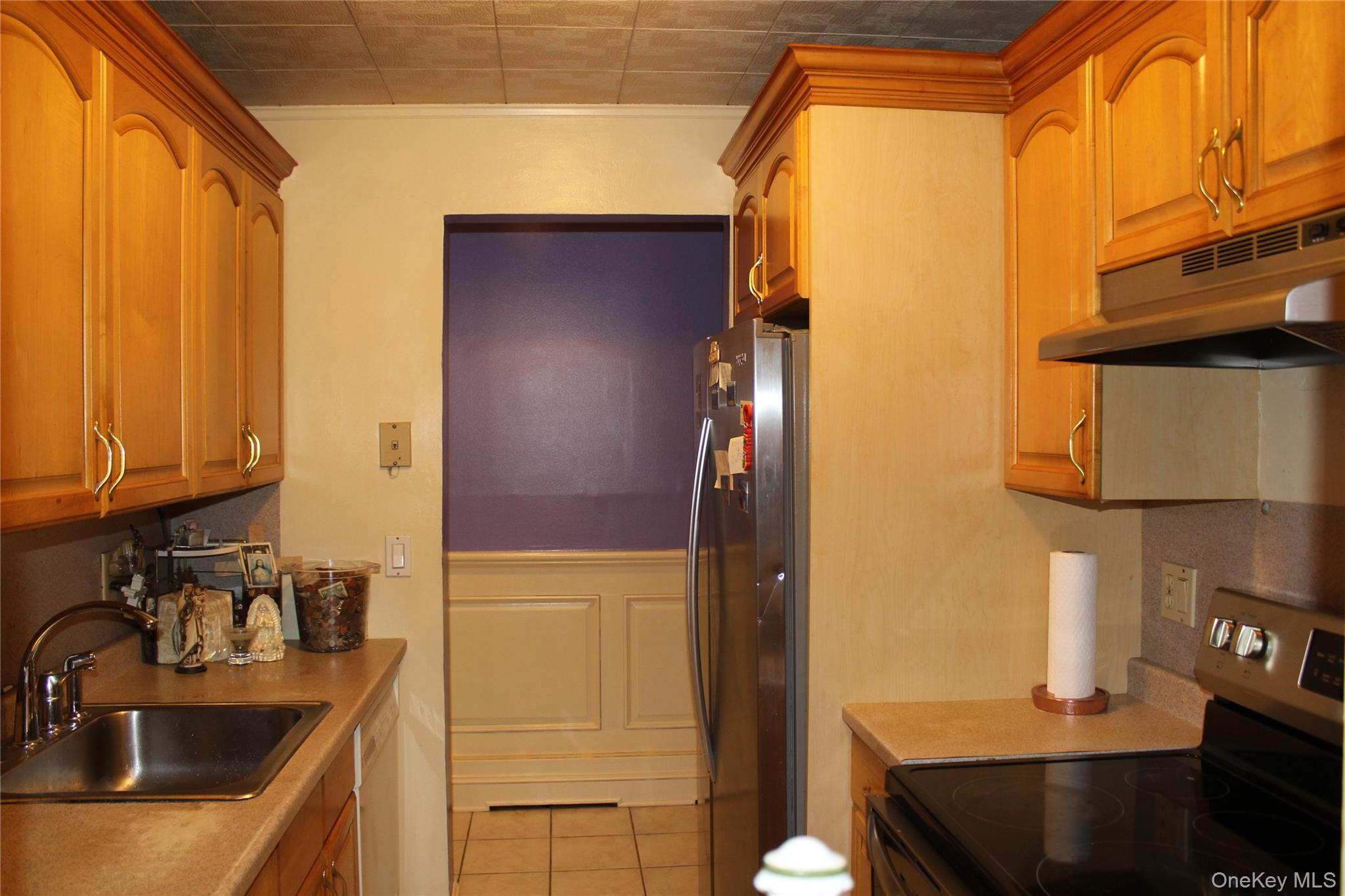 8 Secora Road, Unit J4 Monsey, NY 10952 - Photo 6 of 10 a kitchen with a sink a refrigerator and cabinets