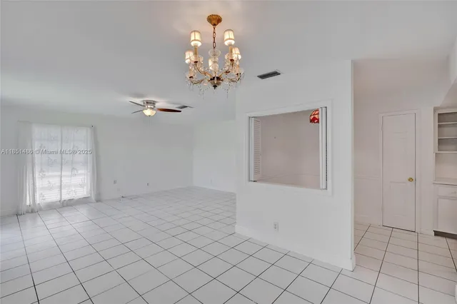 a view of a livingroom with furniture and chandelier fan