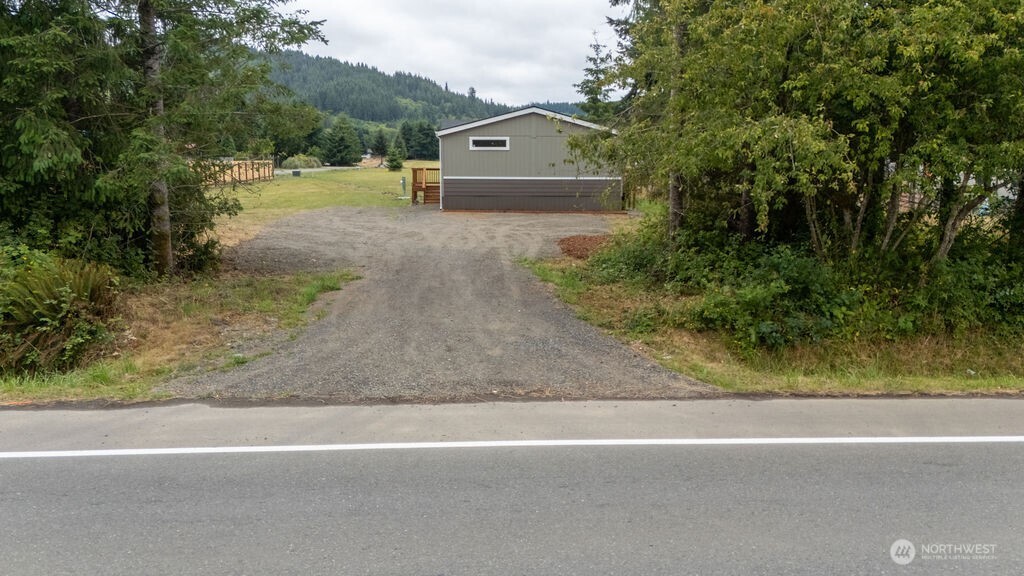 a view of a large house with a yard and large trees