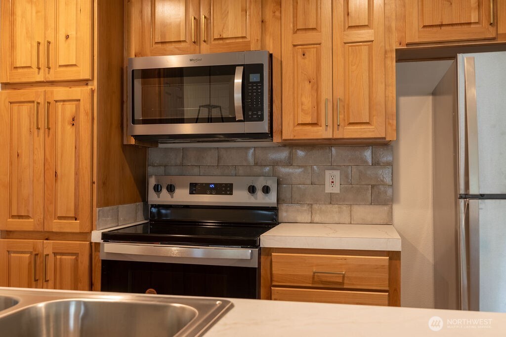 1450 Calawah Way Forks, WA 98331 - Photo 11 of 38 a kitchen with granite countertop cabinets and steel stainless steel appliances
