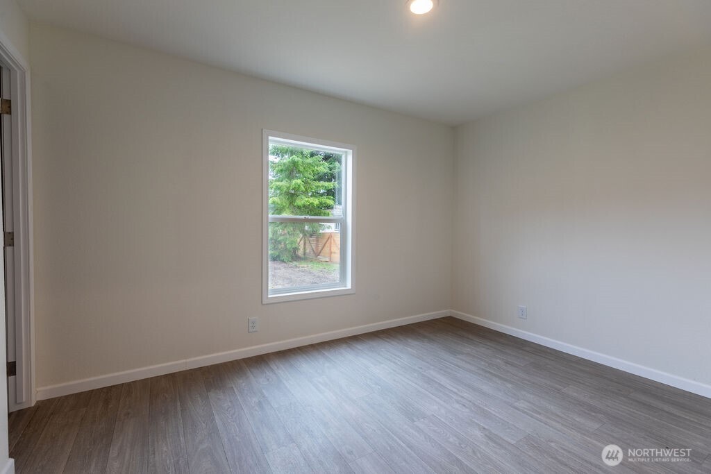 1450 Calawah Way Forks, WA 98331 - Photo 13 of 38 an empty room with wooden floor and windows