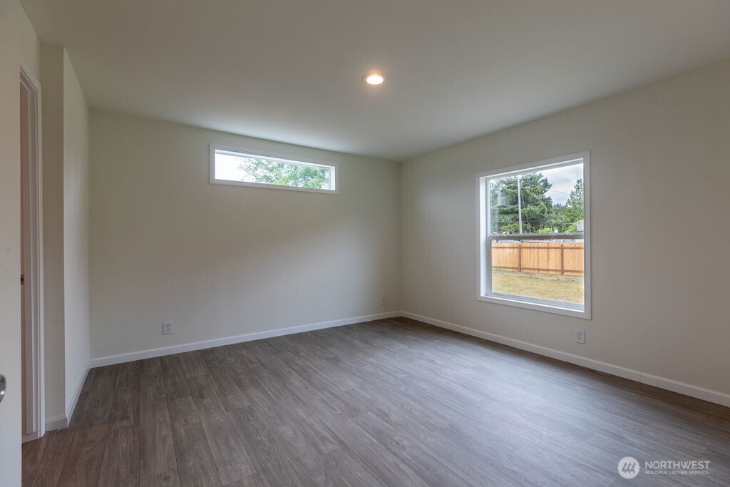 1450 Calawah Way Forks, WA 98331 - Photo 21 of 38 an empty room with wooden floor and windows