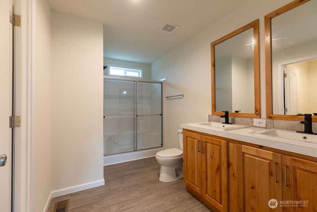 1450 Calawah Way Forks, WA 98331 - Photo 24 of 38 a bathroom with a granite countertop sink a toilet a mirror and shower