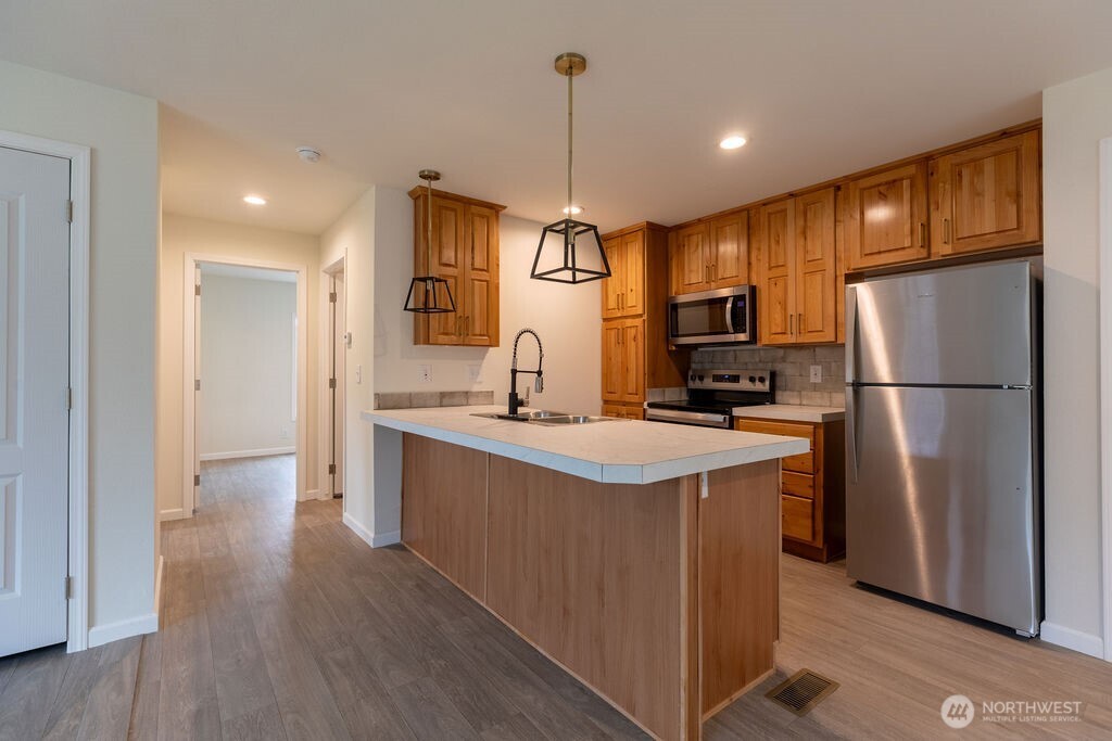 1450 Calawah Way Forks, WA 98331 - Photo 4 of 38 a kitchen with refrigerator cabinets and wooden floor