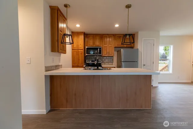 a kitchen with stainless steel appliances granite countertop a refrigerator a sink and a stove