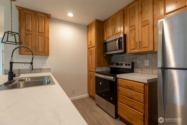 a kitchen with granite countertop stainless steel appliances and wooden cabinets
