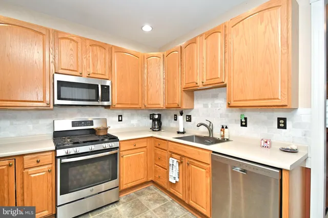 a kitchen with stainless steel appliances a stove a sink and a microwave