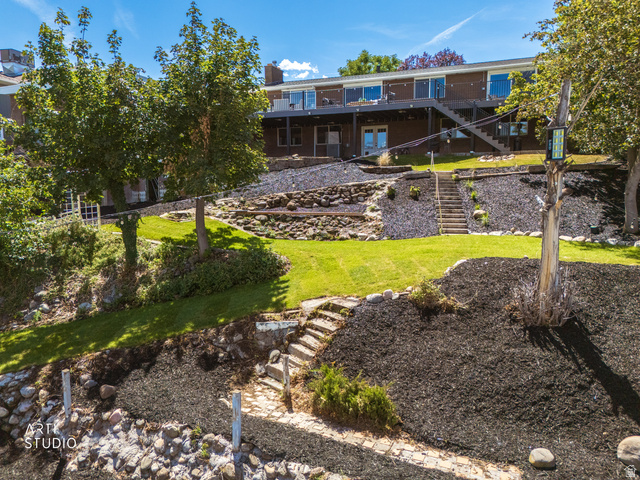 455 Ridge Lane Payson, UT 84651 - Photo 50 of 62 Multi-level backyard with tiered landscaping, manicured lawn, stone retaining walls, and a full length deck with exterior stairs