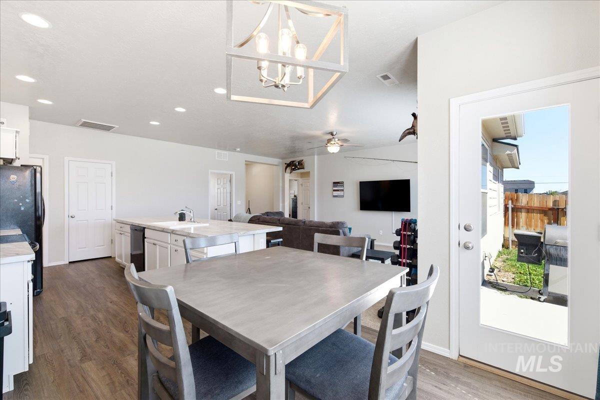 843 Southwest Levant Way Mountain Home, ID 83647 - Photo 13 of 45 Dining area featuring dark wood-style flooring, hanging lights, and a ceiling fan