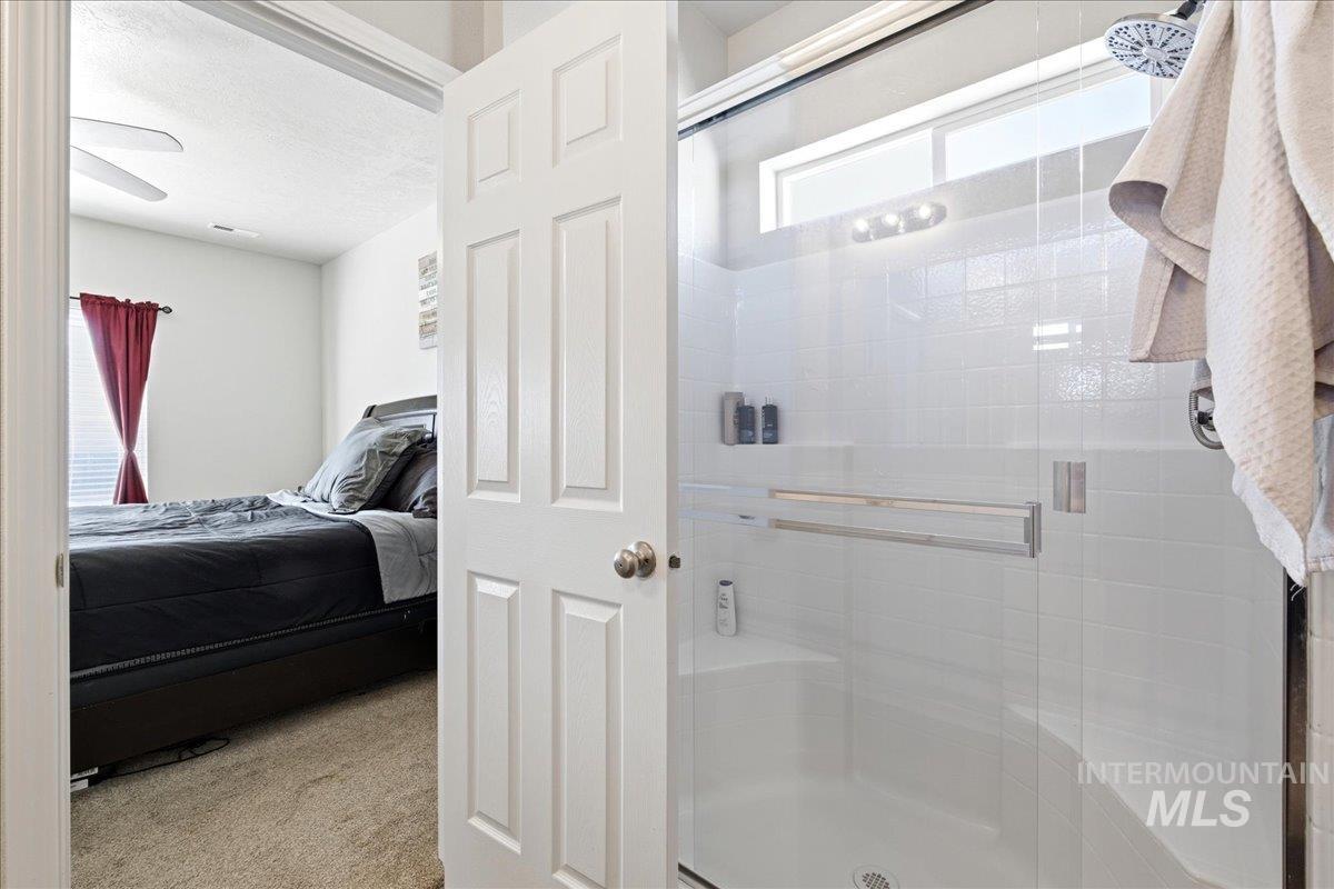 843 Southwest Levant Way Mountain Home, ID 83647 - Photo 15 of 45 Ensuite bathroom featuring a stall shower and light colored carpet