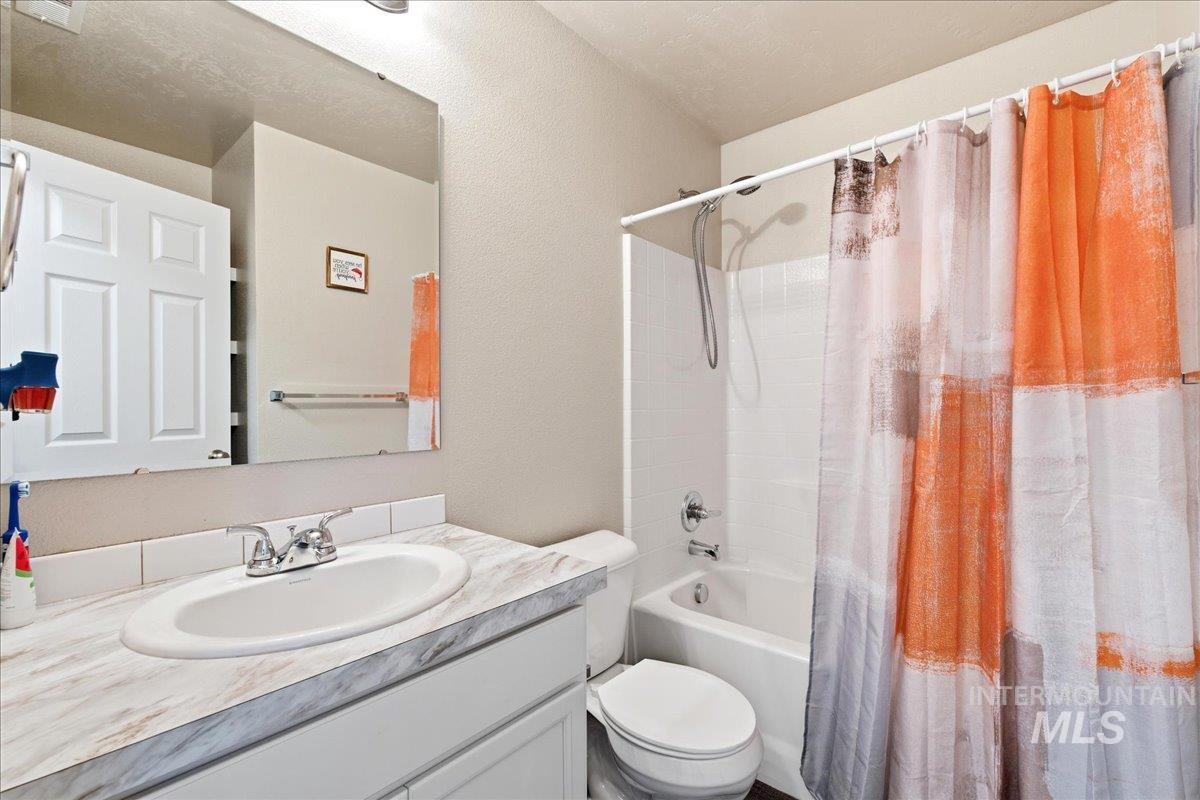 843 Southwest Levant Way Mountain Home, ID 83647 - Photo 20 of 45 Bathroom with vanity, shower / bath combo with shower curtain, and a textured wall