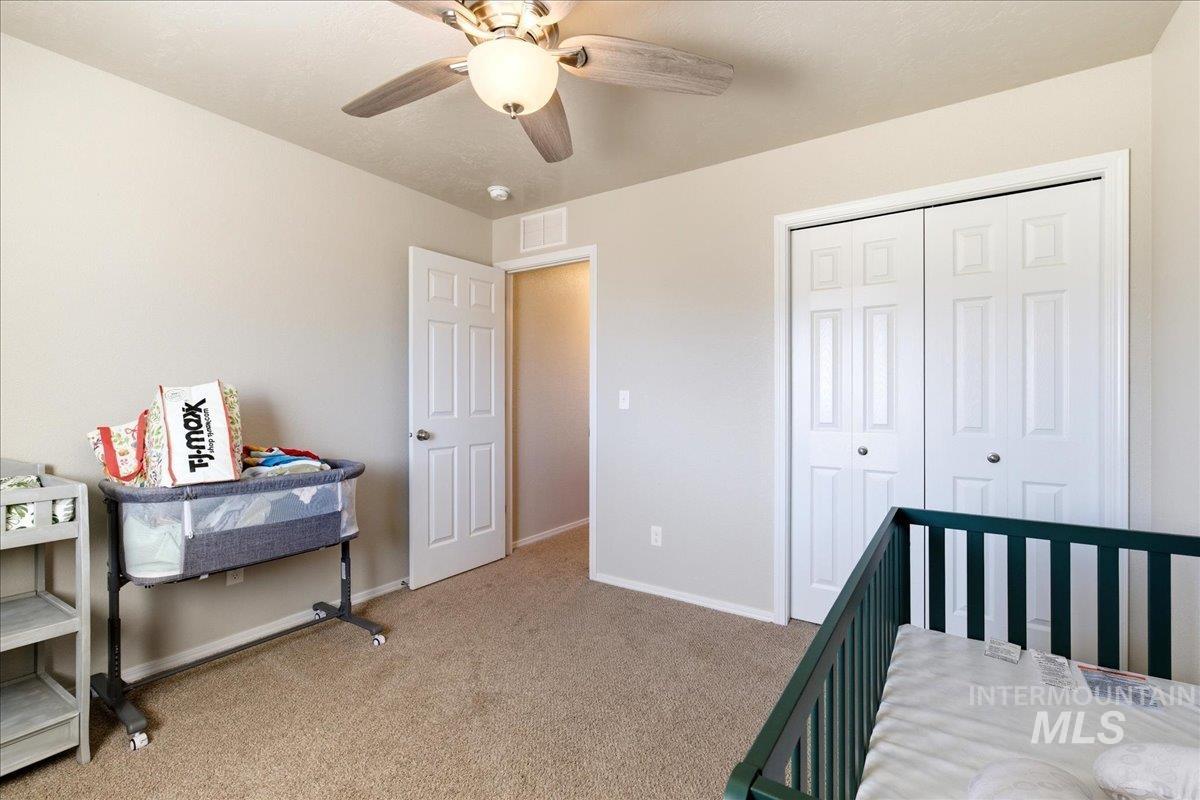 843 Southwest Levant Way Mountain Home, ID 83647 - Photo 22 of 45 Bedroom with light colored carpet, a closet, and ceiling fan